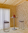 Tonella Stool by Sancal by a high table against a stone wall – In Dubai by WSPR