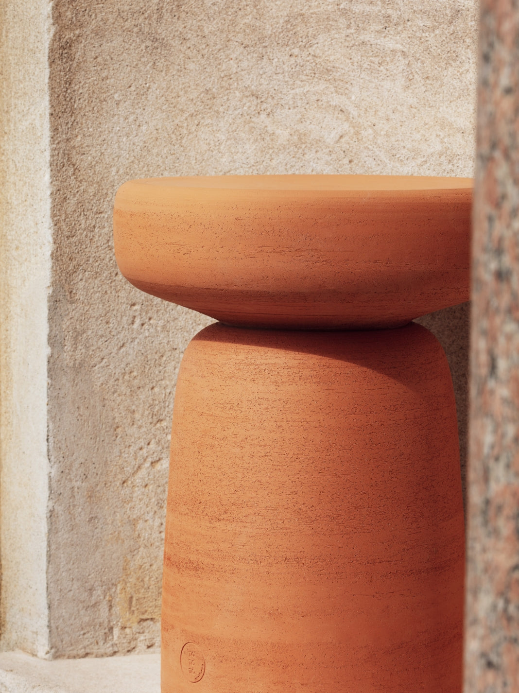 Tototò Coffee Table by Miniforms in natural terracotta, side detail against a stone wall – In Dubai by WSPR