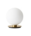 TR Bulb Table/Wall Lamp by Audo in matte brass, front view of the opal glass sphere on its round base – In Dubai by WSPR